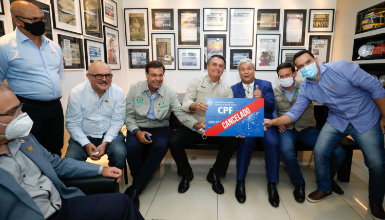 Bolsonaro ignora mortes por covid e posa para foto com placa CPF cancelado
